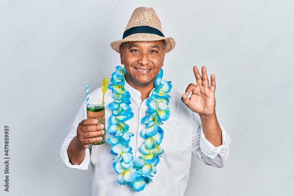 Middle age latin man wearing summer style drinking mojito glass doing ok sign with fingers, smiling friendly gesturing excellent symbol Middle age latin man wearing summer style drinking mojito glass doing ok sign with fingers, smiling friendly gesturing excellent symbol