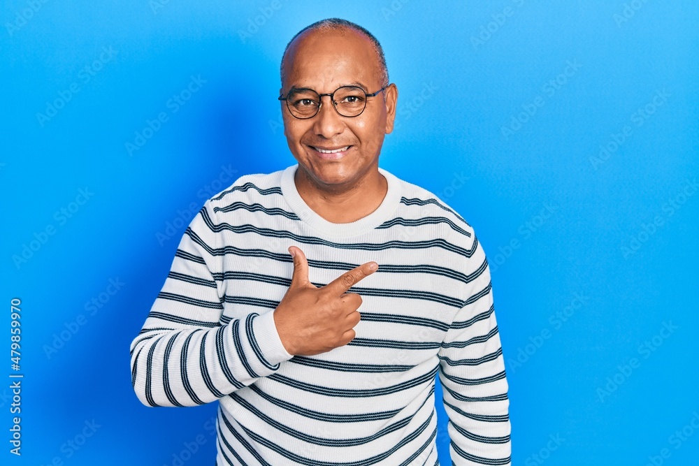 Middle age latin man wearing casual clothes and glasses cheerful with a smile on face pointing with hand and finger up to the side with happy and natural expression Middle age latin man wearing casual clothes and glasses cheerful with a smile on face pointing with hand and finger up to the side with happy and natural expression