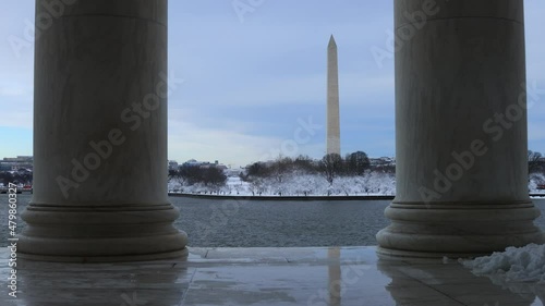 The Washington Monument and White House are seen from across the Tidal Basin, framed by two columns in the Jefferson Memorial. Snow can be seen following a winter storm in Washington, D.C.  photo