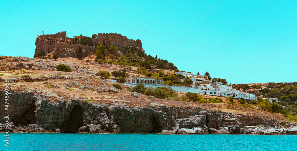 Lindos bay view on Rhodes island, seascape with coast greek village and ancient castle Lindos bay view on Rhodes island, seascape with coast greek village and ancient castle