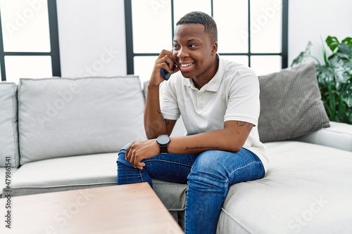 Young african man speaking on the phone at home