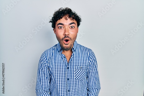Young hispanic man wearing casual clothes afraid and shocked with surprise expression, fear and excited face.