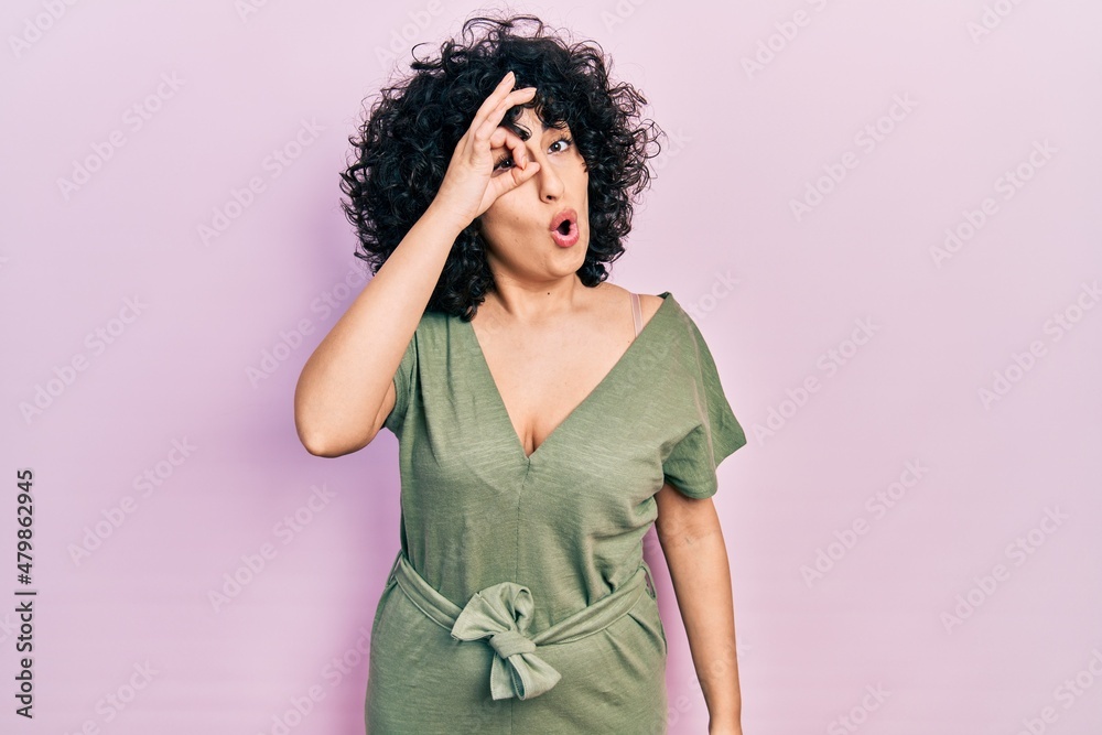 Young middle east woman wearing casual clothes doing ok gesture shocked with surprised face, eye looking through fingers. unbelieving expression. Young middle east woman wearing casual clothes doing ok gesture shocked with surprised face, eye looking through fingers. unbelieving expression.