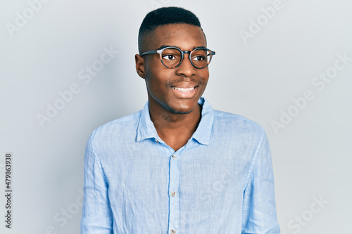 Young african american man wearing casual clothes and glasses looking to side, relax profile pose with natural face and confident smile.