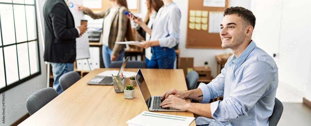 Young business worker smiling happy working while partners have break time at the office. Young business worker smiling happy working while partners have break time at the office.