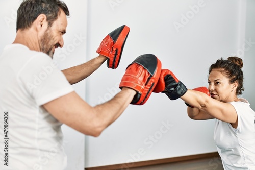 Middle age hispanic couple smiling happy training boxing at home. © Krakenimages.com