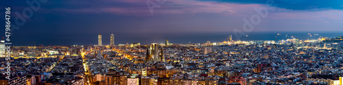 Aerial rooftop panorama of Barcelona at dusk. Spain