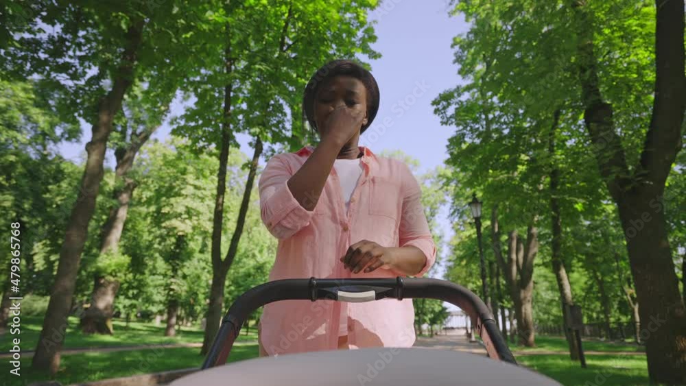 Mom leaning to baby in stroller, feeling unpleasant smell, time to change diaper