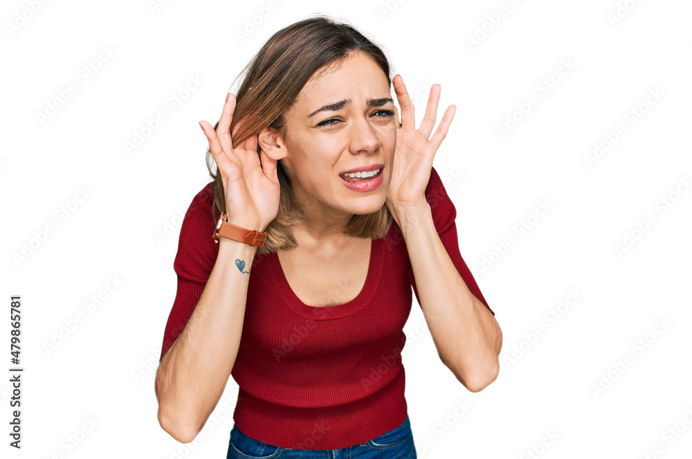 Young blonde girl wearing casual clothes trying to hear both hands on ear gesture, curious for gossip. hearing problem, deaf Young blonde girl wearing casual clothes trying to hear both hands on ear gesture, curious for gossip. hearing problem, deaf