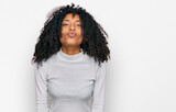 Young african american girl wearing casual clothes looking at the camera blowing a kiss on air being lovely and sexy. love expression.