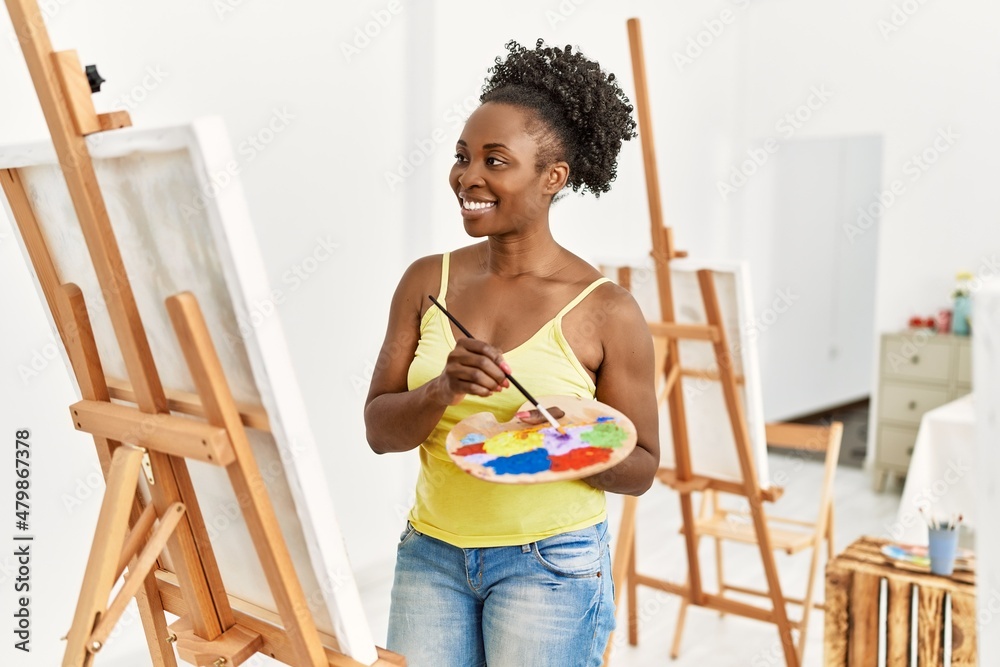 Young african american artist woman smiling happy drawing at art studio. Young african american artist woman smiling happy drawing at art studio.
