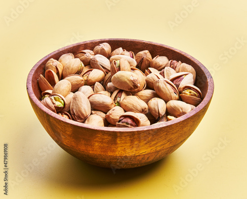  Bowl of pistachios over yellow background