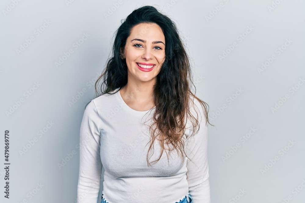 Young hispanic woman wearing casual clothes with a happy and cool smile on face. lucky person. Young hispanic woman wearing casual clothes with a happy and cool smile on face. lucky person.