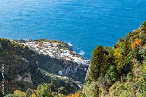 The Italian village of Praiano, seen from above, from the Path of the Gods (Sentiero degli Dei) along the scenic Amalfi Coast of Italy, with the blue Tyrrhenian Sea and blue sky and clouds photo