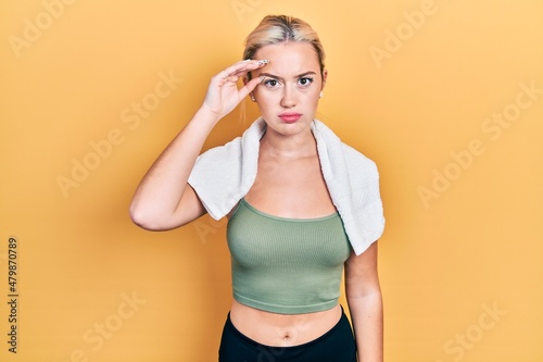 Young blonde girl wearing sportswear and towel worried and stressed about a problem with hand on forehead, nervous and anxious for crisis © Krakenimages.com