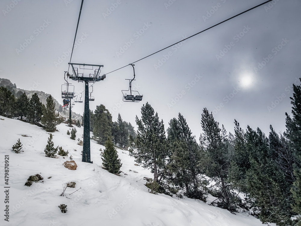 snowy landscape among the pines of a ski resort, seen from a ski lift, on a snowy day snowy landscape among the pines of a ski resort, seen from a ski lift, on a snowy day