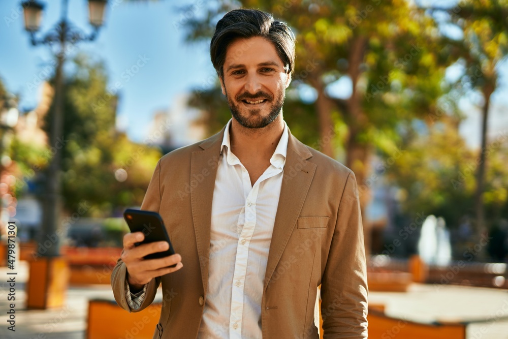 Young hispanic businessman smiling happy using smartphone at the city. Young hispanic businessman smiling happy using smartphone at the city.