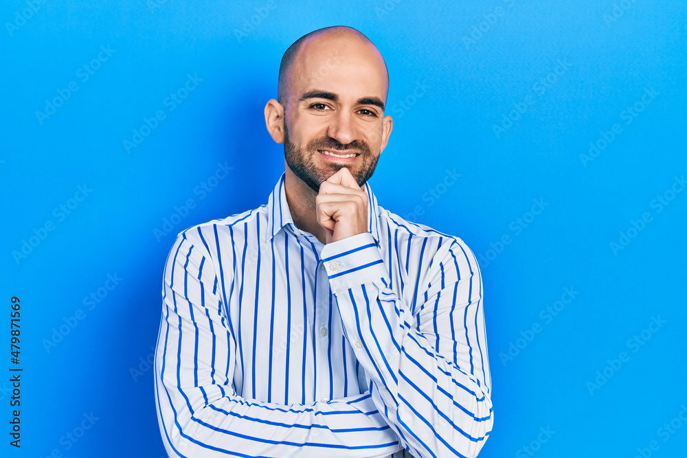 Young bald man wearing elegant clothes smiling looking confident at the camera with crossed arms and hand on chin. thinking positive. Young bald man wearing elegant clothes smiling looking confident at the camera with crossed arms and hand on chin. thinking positive.