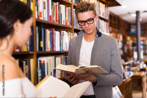 portrait of intelligent man searching for information in books in bookstore