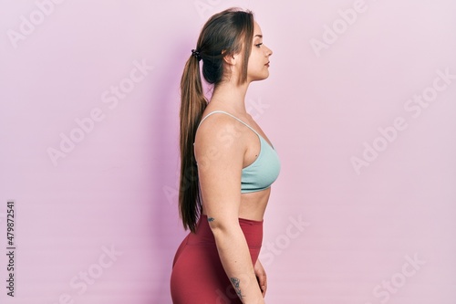 Fototapeta Naklejka Na Ścianę i Meble -  Young hispanic girl wearing sportswear looking to side, relax profile pose with natural face with confident smile.