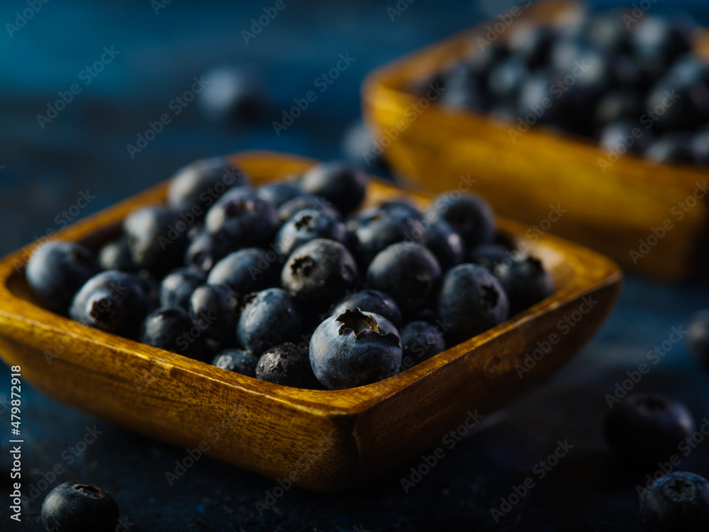 Many fresh blueberries in bowls on a blue background. Vitamin product, antioxidants, healthy food. Juices, juices, pie fillings, sauces. Delicious healthy breakfast.