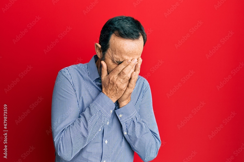 Middle age hispanic man wearing casual clothes with sad expression covering face with hands while crying. depression concept. Middle age hispanic man wearing casual clothes with sad expression covering face with hands while crying. depression concept.