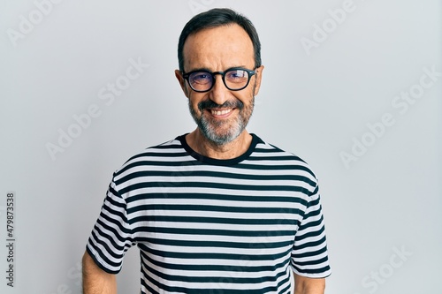 Middle age hispanic man wearing casual clothes and glasses with a happy and cool smile on face. lucky person.
