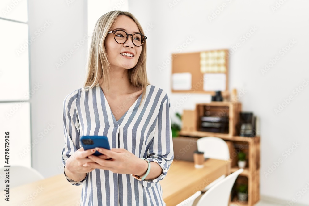 Young chinese woman smiling confident using smartphone at office Young chinese woman smiling confident using smartphone at office