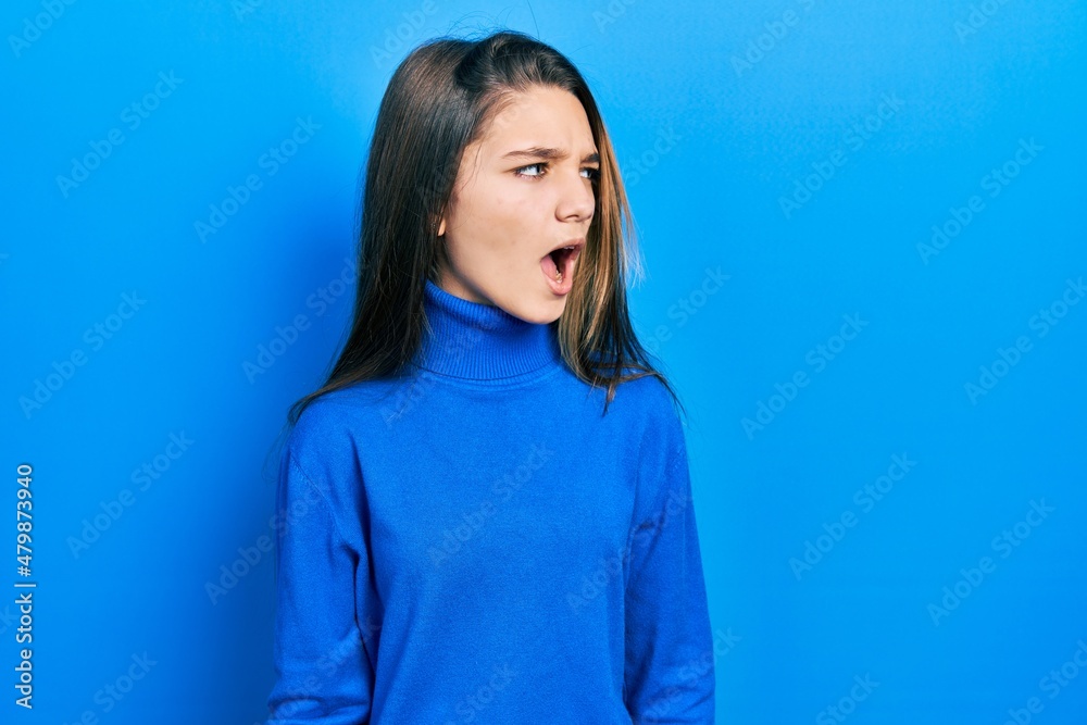 Fototapeta premium Young brunette girl wearing turtleneck sweater angry and mad screaming frustrated and furious, shouting with anger. rage and aggressive concept.