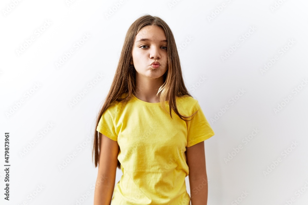 Young brunette teenager standing together over isolated background looking at the camera blowing a kiss on air being lovely and sexy. love expression. Young brunette teenager standing together over isolated background looking at the camera blowing a kiss on air being lovely and sexy. love expression.
