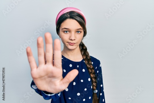 Young brunette girl wearing elegant look doing stop sing with palm of the hand. warning expression with negative and serious gesture on the face.