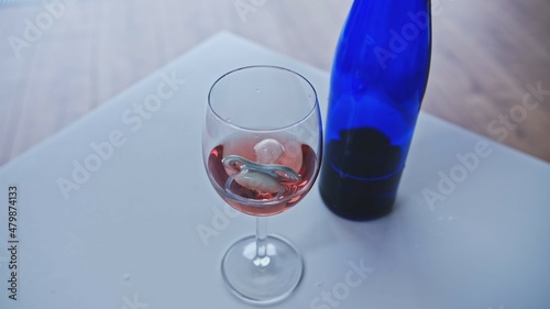 Newborn Baby Soother Sucker Floating in Glass of Rose Wine left on Table by Addicted Drinking Breastfeeding or Expecting Mother Risking Development of Fetal Alcohol Spectrum Disorder photo