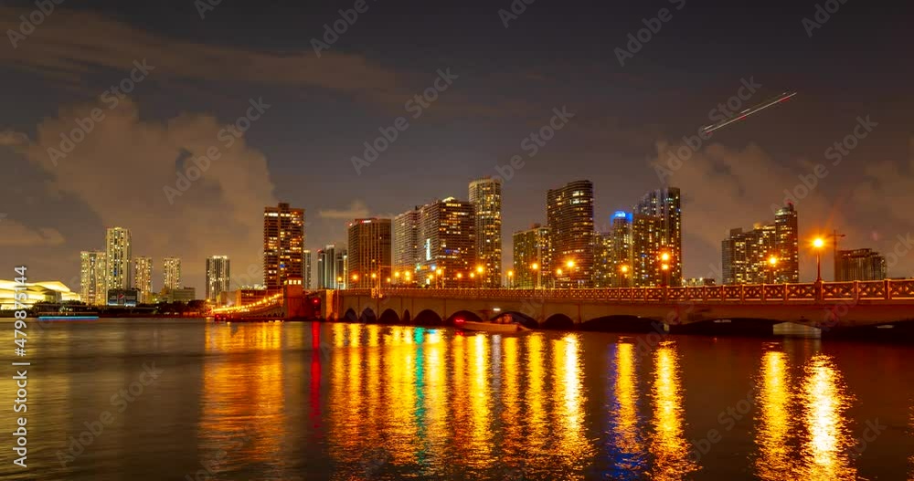 Miami panorama time lapse. Time lapse of sunset on cityscape sky and clouds moving with water ripple reflection. Night sky timelapse on Miami beach city. Cityscape with ocean water.