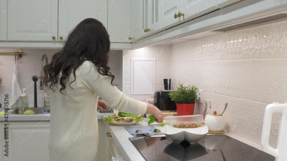 Woman cooking festive dinner in the kitchen making toast with cucumber and caviar. Bread topped with cream cheese, cucumber and salmon roe. High quality 4k footage Woman cooking festive dinner in the kitchen making toast with cucumber and caviar. Bread topped with cream cheese, cucumber and salmon roe. High quality 4k footage