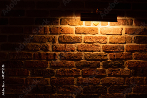 Brick wall illuminated by warm light from a lamp