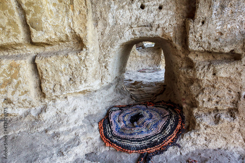 Entrance to the rocky monastery for kneeling crawling. Background with copy space photo