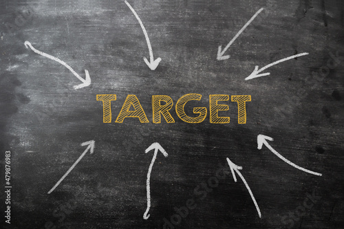 arrows on the chalkboard pointing to the word target in the center. Marketing research concept.
