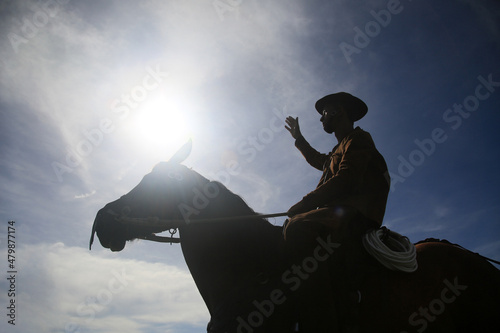 conde, bahia, brasil - january 8, 2022: Cowboy wearing traditional leather clothes with his horse on a farm in the city of Conde. photo