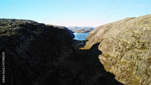 Aerial shot of a large gorge with a big fjord in the background, sunny day in norway photo