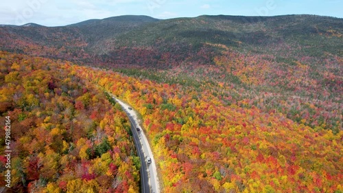Cars driving Mountain pass in New England during fall with changing leaves photo