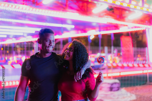 Young smiling couple having a ride on a amusement park. Couple Dating Amusement Park Enjoyment of the fair. photo