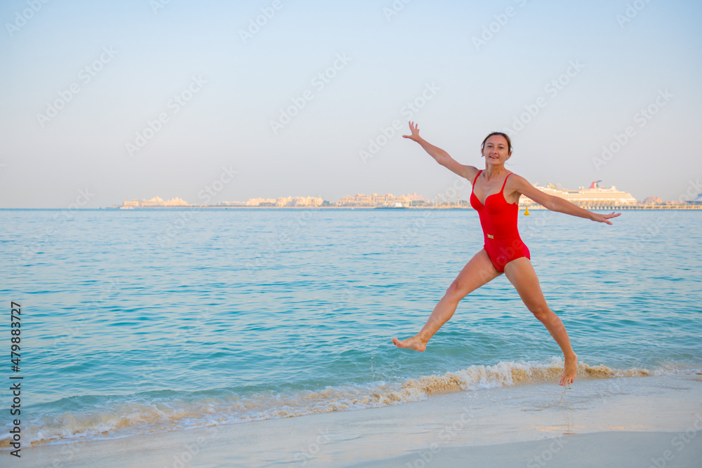 beautiful girl in a swimsuit jumping on the beach beautiful girl in a swimsuit jumping on the beach
