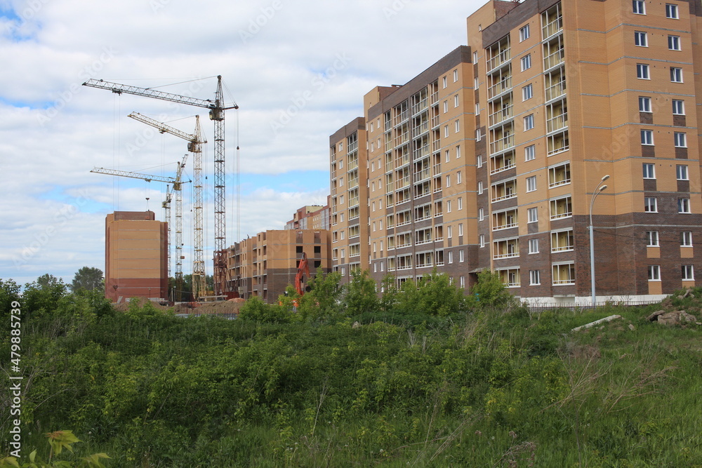 Russia, Novosibirsk 10.06.2021: construction of multi-storey modern buildings for the city with houses crane on an industrial site