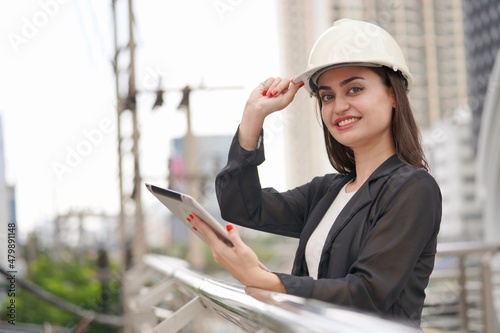 Portrait of beautiful architect or civil engineer wearing hardhat use digital tablet, Engineering and architure concept. photo