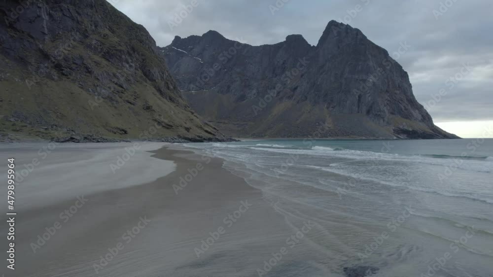 Aerial drone view circling low over tranquil beach, in cloudy Kvalvika, in Lofoten, Norway Aerial drone view circling low over tranquil beach, in cloudy Kvalvika, in Lofoten, Norway