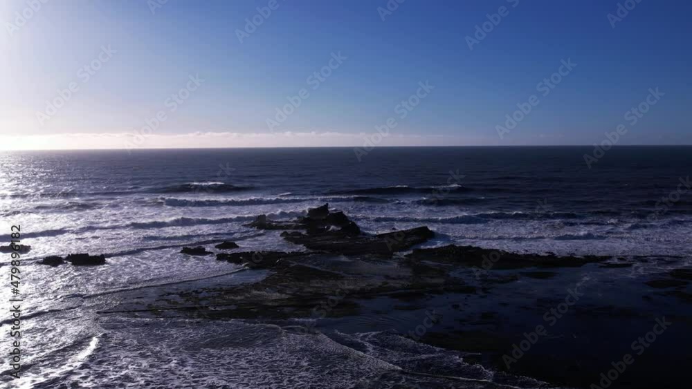 Drone push in towards rock formation at low tide. Waves breaking over tide pools at Mavericks Beach, California. Slow motion: 59.94 FPS. Drone push in towards rock formation at low tide. Waves breaking over tide pools at Mavericks Beach, California. Slow motion: 59.94 FPS.