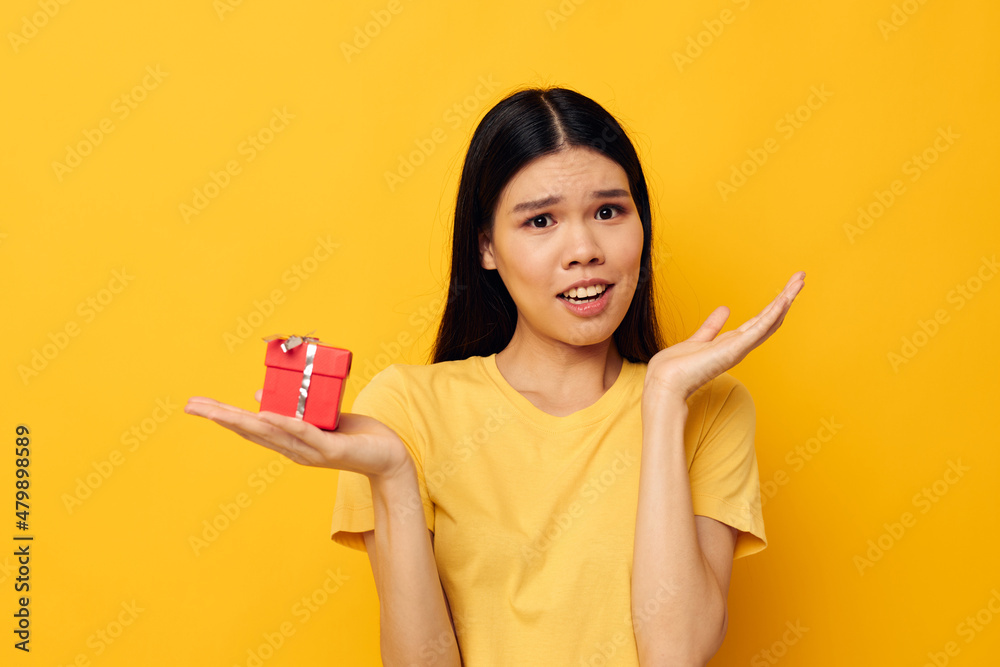 Portrait Asian beautiful young woman holding a gift box in his hands posing isolated background unaltered Portrait Asian beautiful young woman holding a gift box in his hands posing isolated background unaltered
