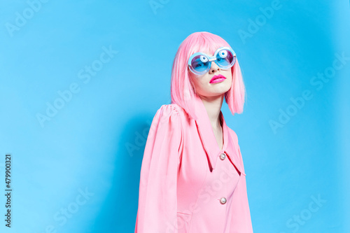 woman in pink wig and dress on blue background © SHOTPRIME STUDIO