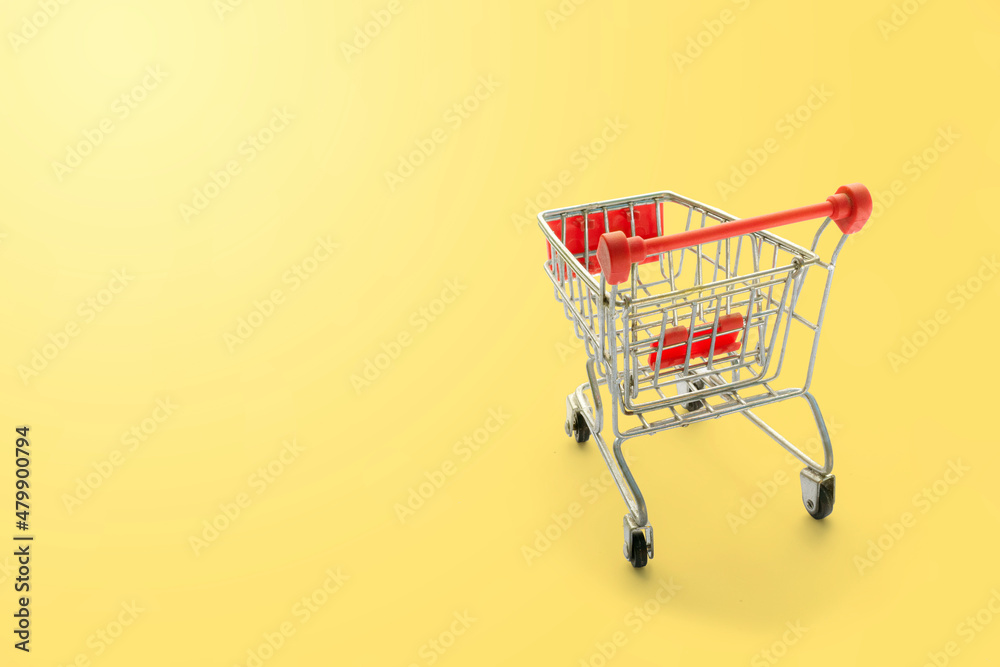 shopping trolley on yellow background with some copy space. shopping trolley on yellow background with some copy space.