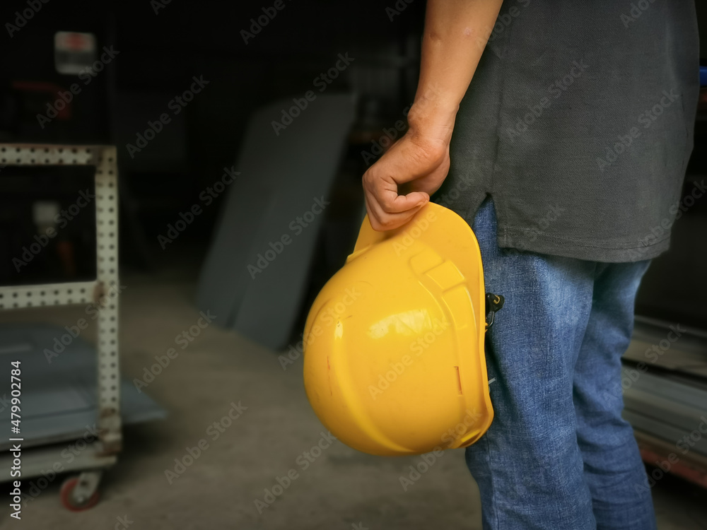 Man hold yellow safety helmet in the factory. Man hold yellow safety helmet in the factory.